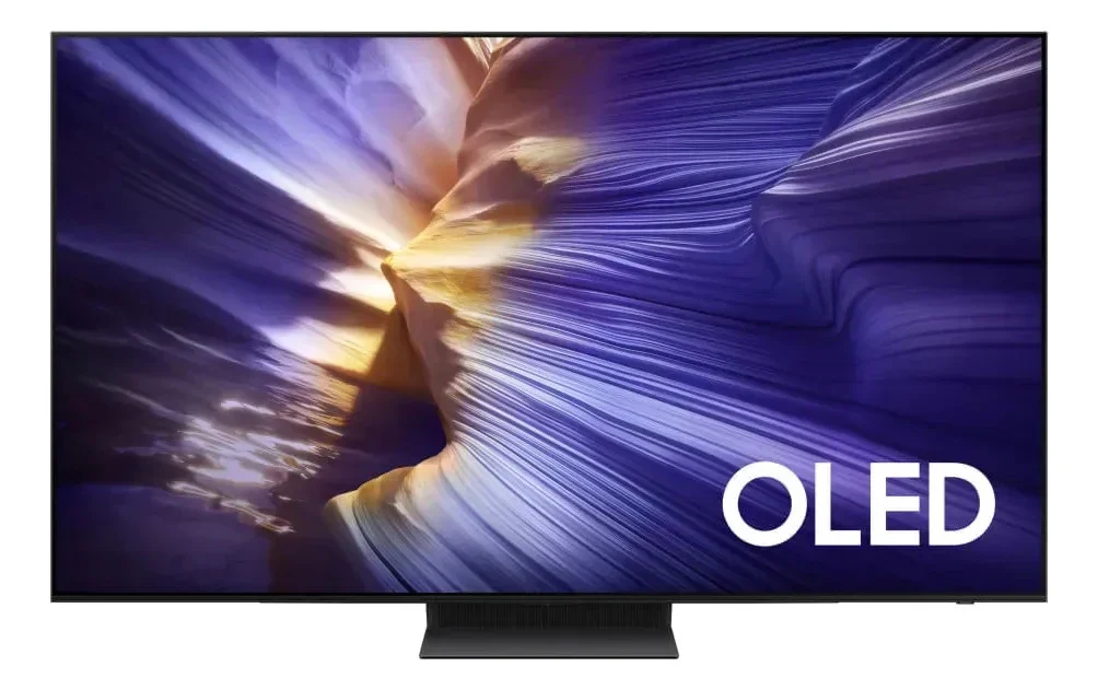 Samsung OLED S90F: TV OLED de frente em fundo branco, com base central escura e tela exibindo paisagem colorida em tons de roxo e laranja
