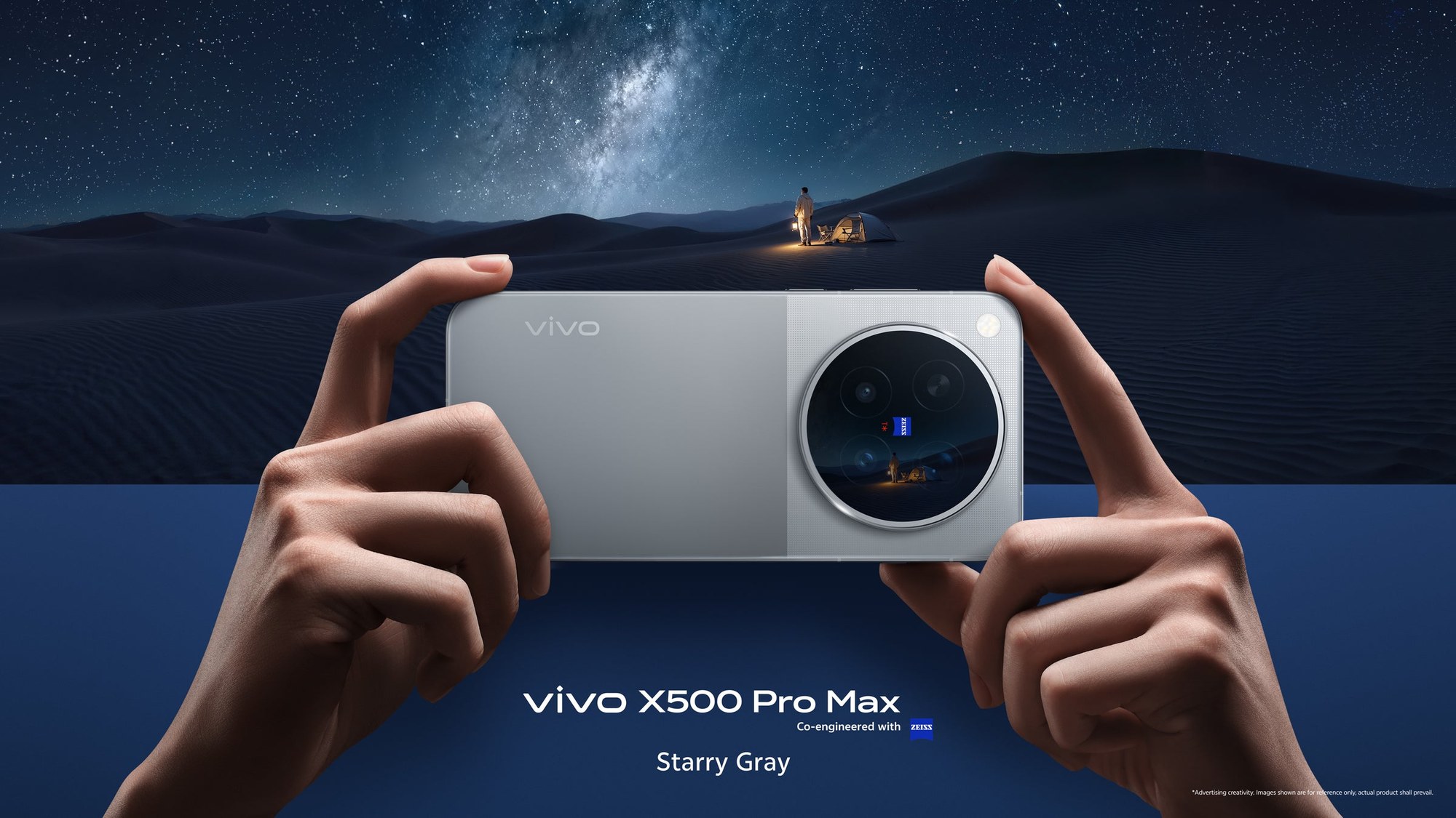 Mãos seguram na horizontal o vivo X500 Pro Max na cor Starry Gray (cinza), visto de costas, com o módulo circular de câmeras Zeiss, diante de um deserto sob céu estrelado; o nome do modelo aparece embaixo da imagem.